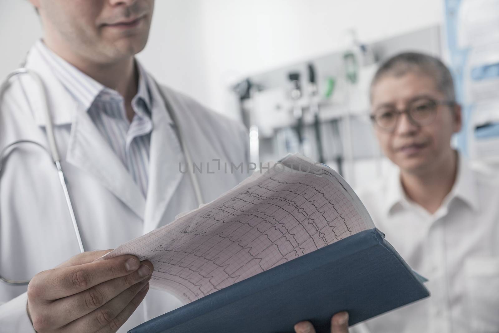 Doctor checking medical chart with patient in the background