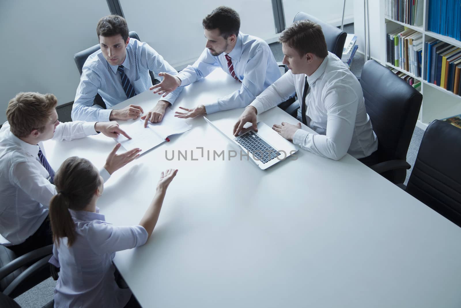 Five business people having a business meeting at the table in the office 