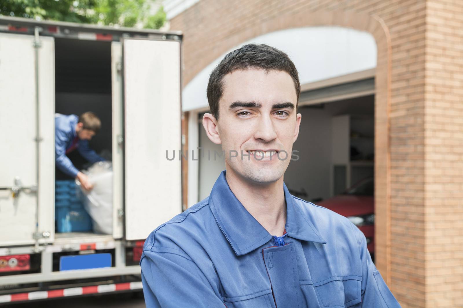 Portrait of smiling mover with moving truck in the background