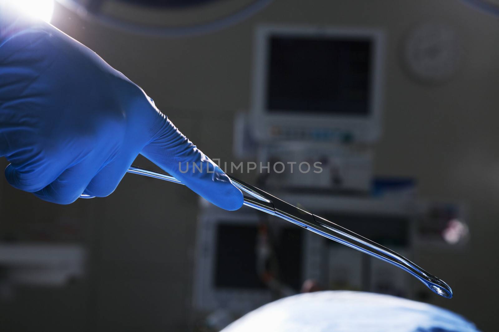 Close-up of gloved hand holding surgical scissors, operating room, hospital