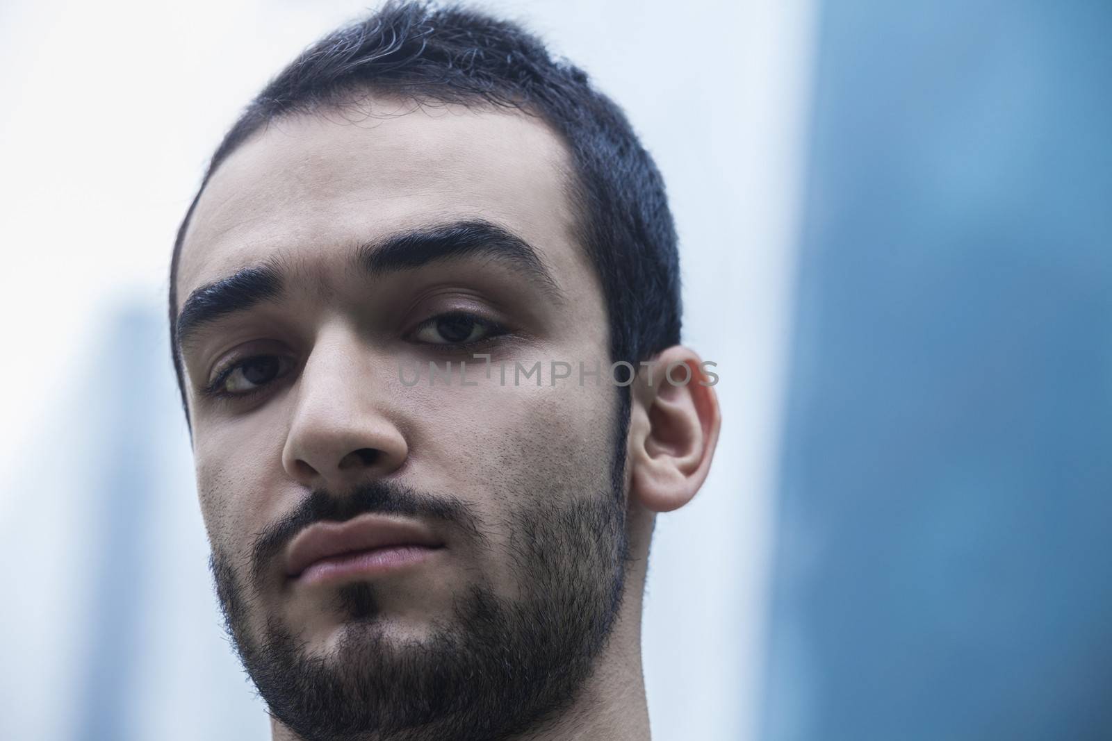Portrait of serious young businessman, outdoors, business district, close-up