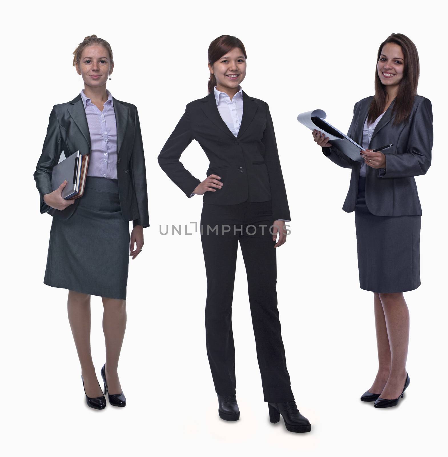 Portrait of three young smiling businesswomen, looking at camera, studio shot