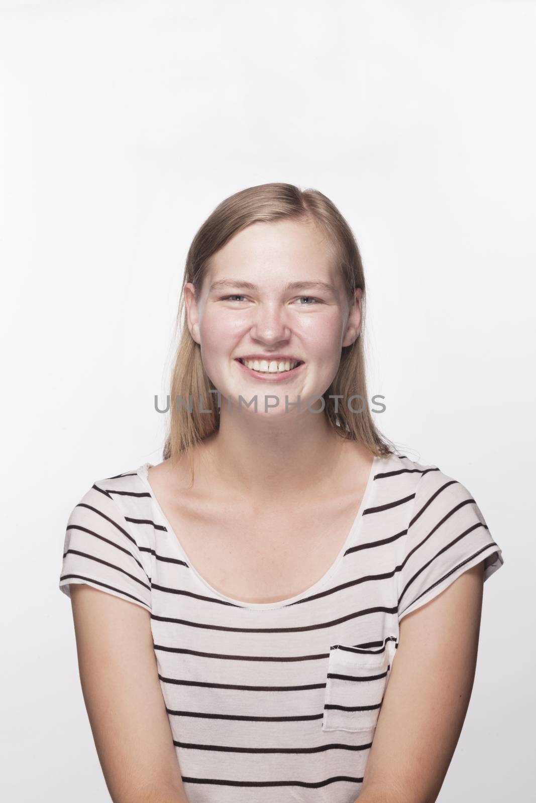 Portrait of teenage girl with blond hair smiling, studio shot by XiXinXing