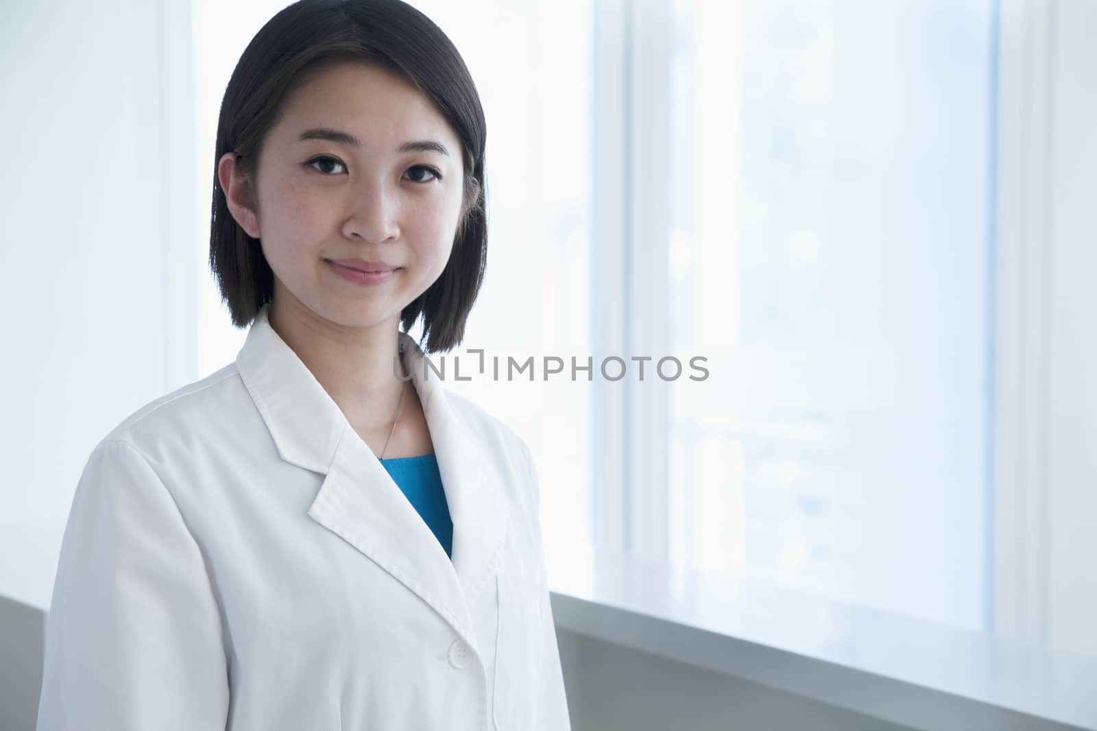 Portrait of young female doctor in the hospital, looking at camera