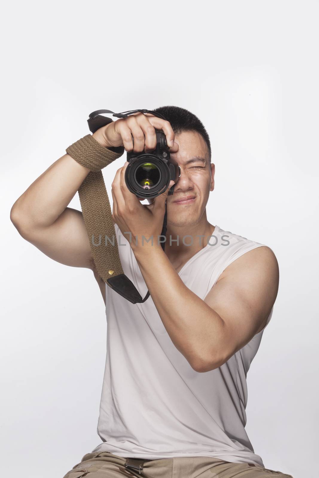 Man holding a camera and taking a photograph, studio shot