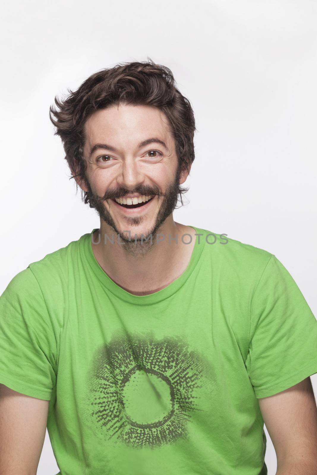 Smiling young man with beard and moustache looking at camera, studio shot