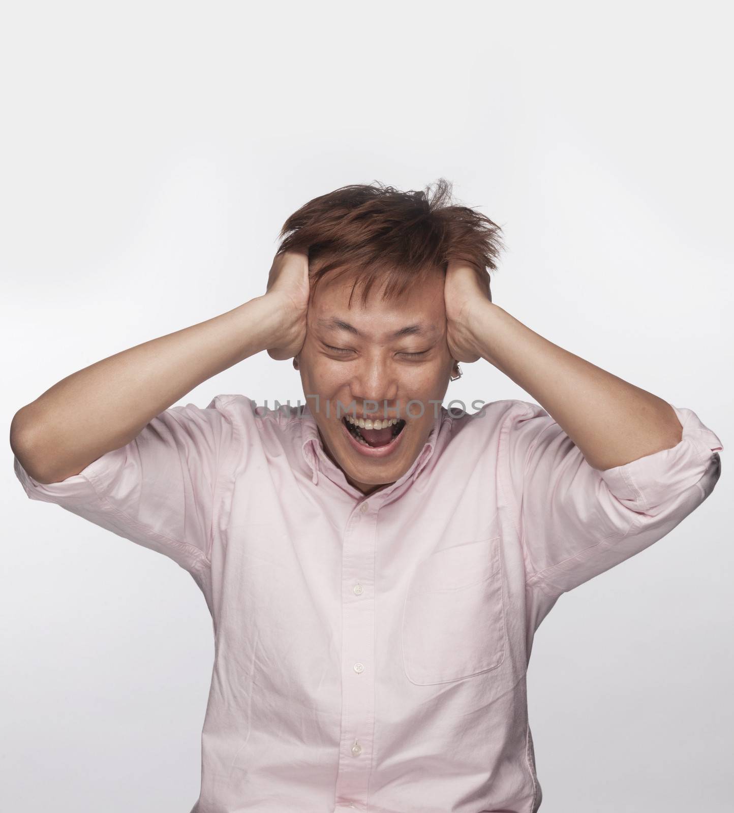 Frustrated man with hands on head and mouth open, studio shot by XiXinXing