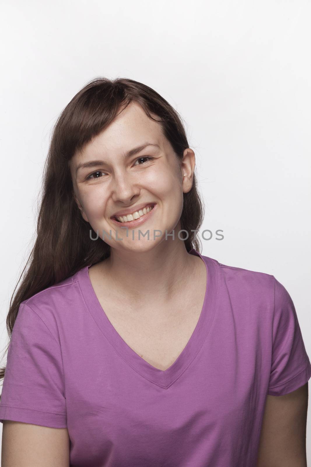 Portrait of smiling young woman in purple t-shirt, studio shot