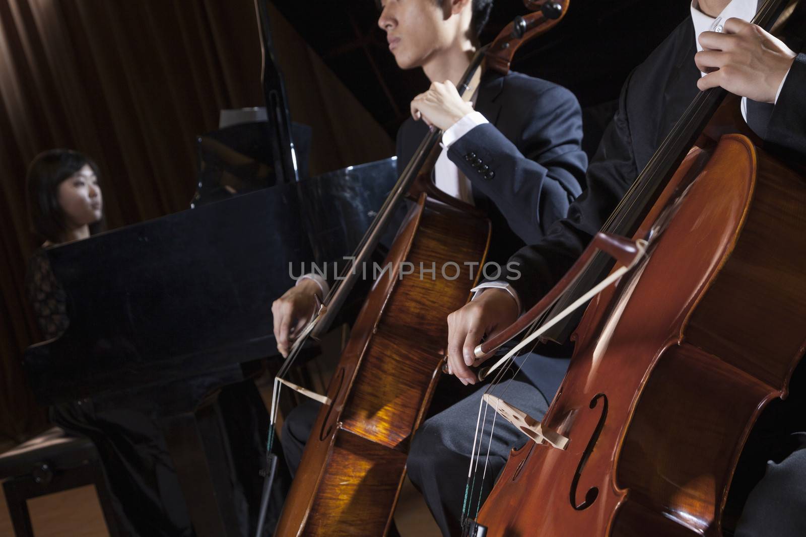 Two cellists playing the cello during a performance