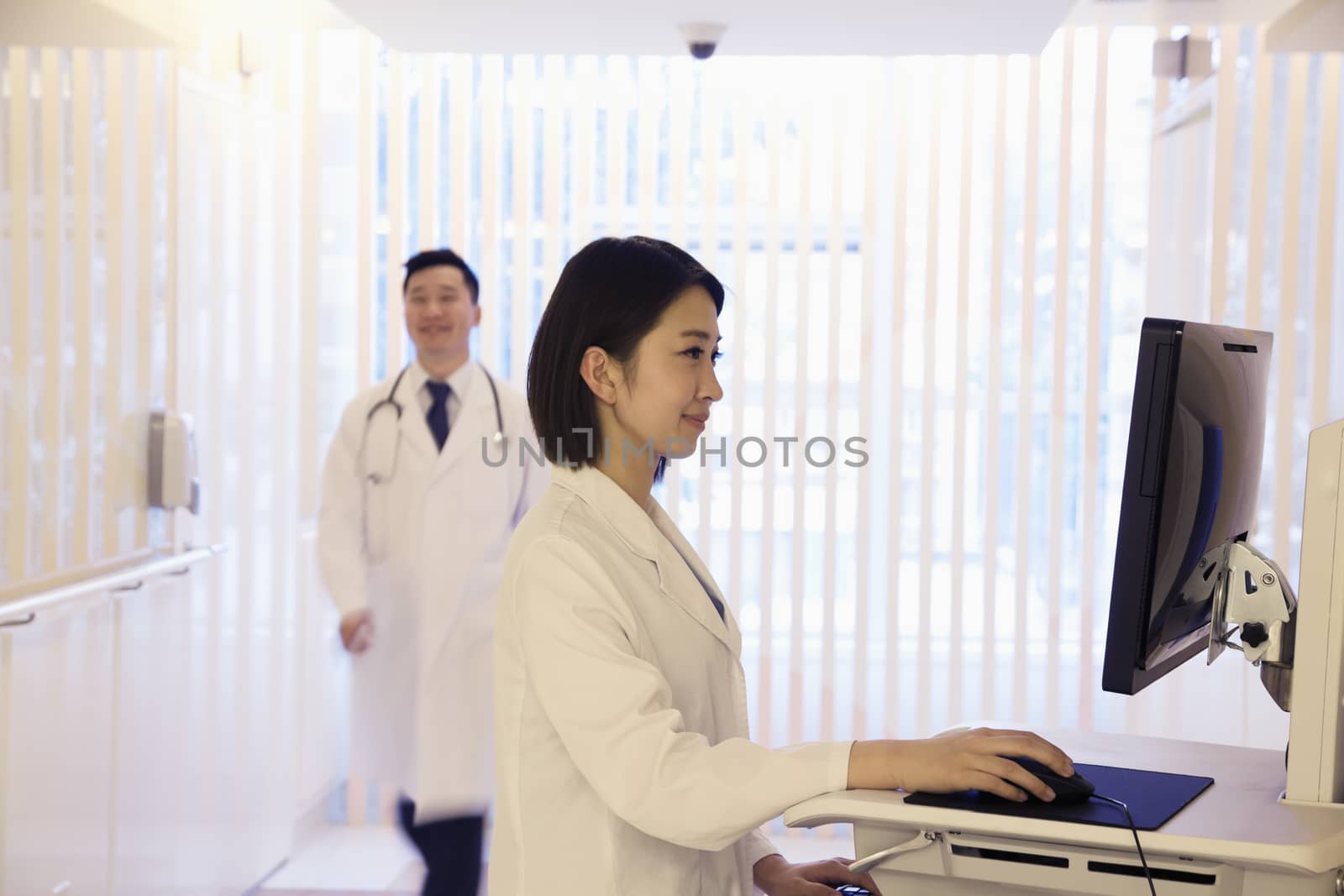 Young female doctor using the computer in the hospital, Beijing, China