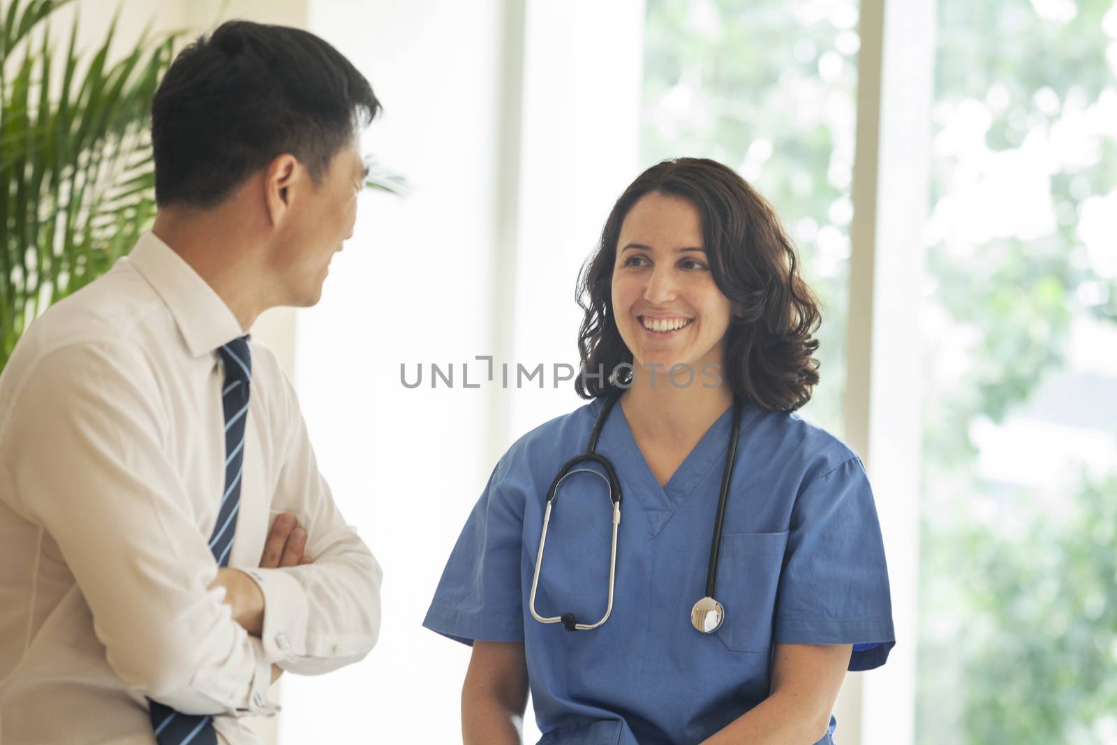 Female nurse and patient talking and smiling in the hospital