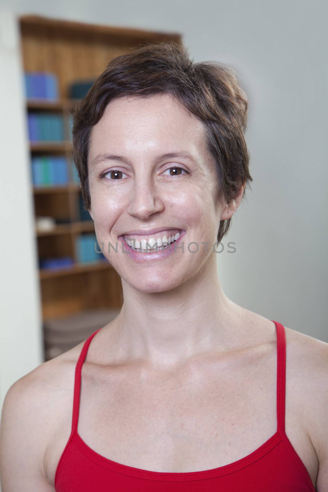 Portrait of smiling woman in a yoga studio, head and shoulders