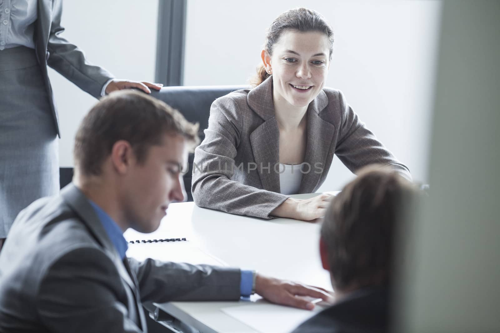 Four smiling business people sitting at a table and having a business meeting in the office