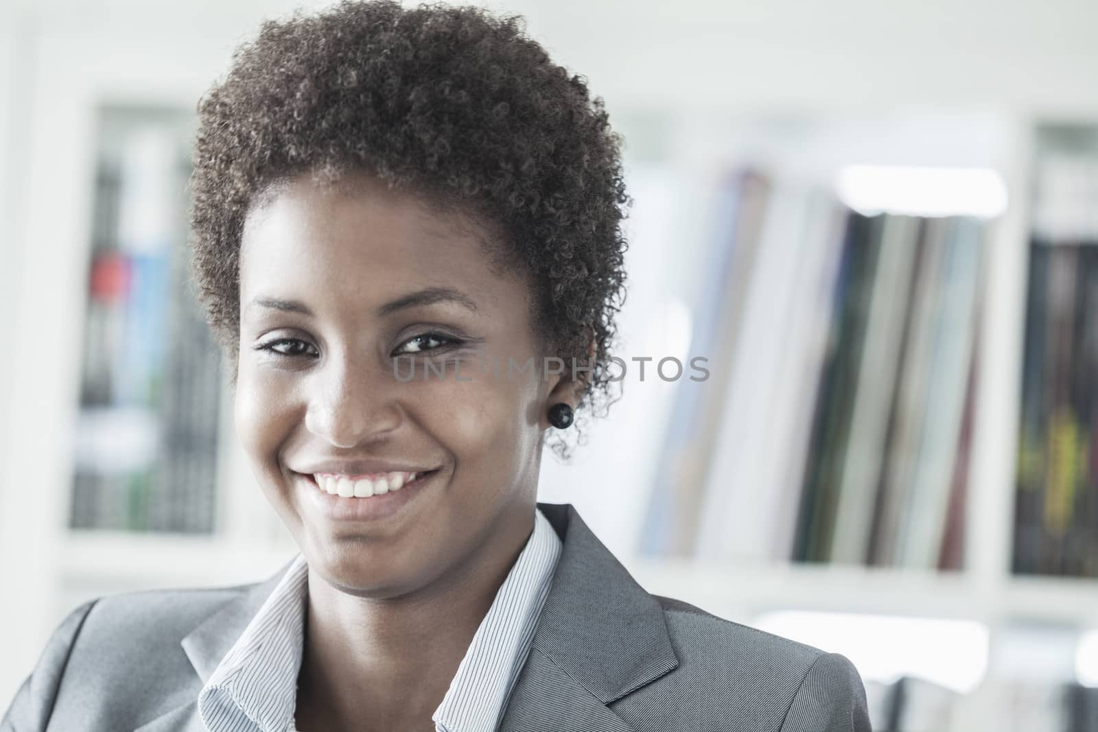 Portrait of smiling young businesswoman with short hair looking at the camera, head and shoulders