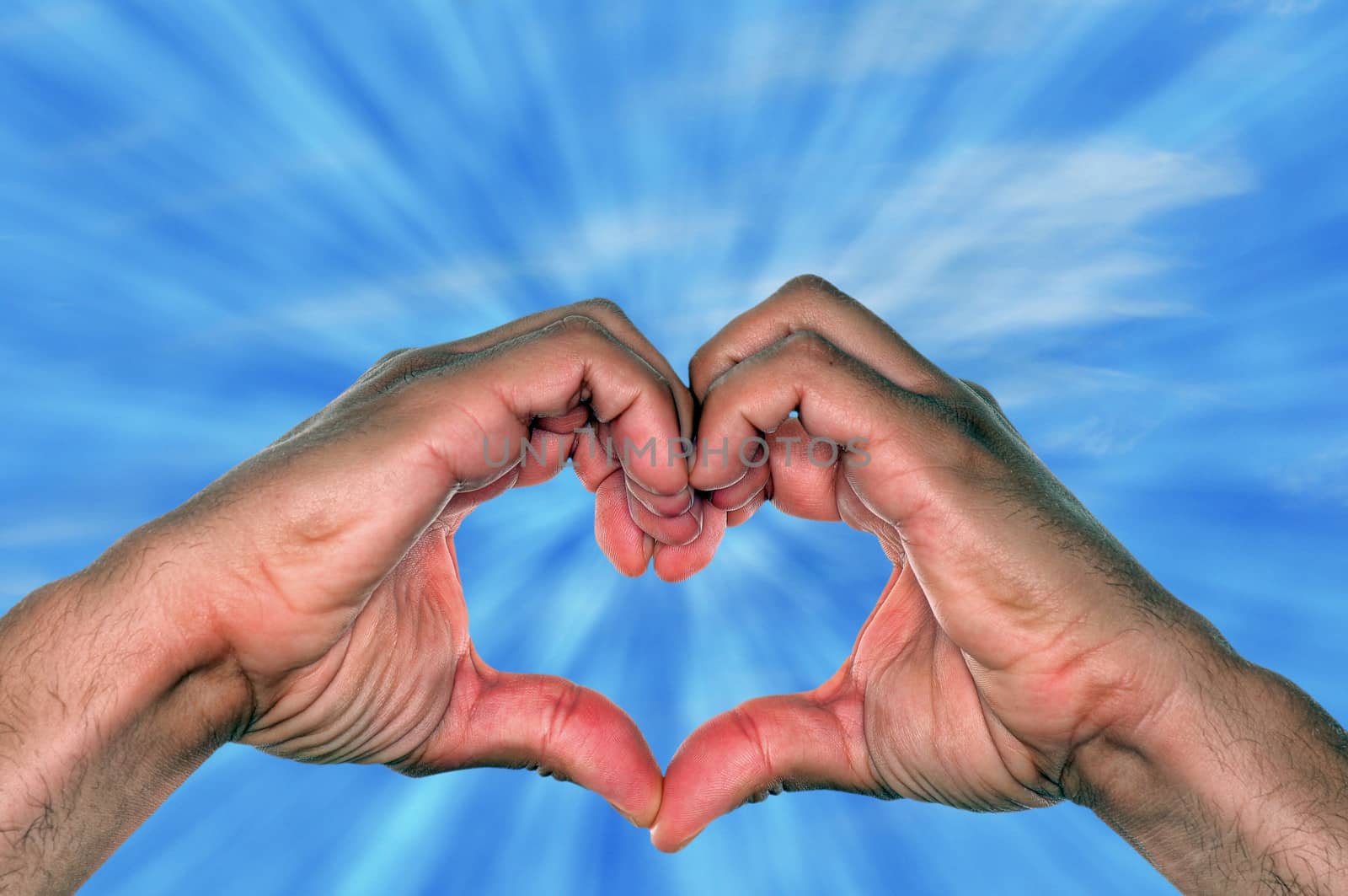 hands making heart shape against sky with sun rays for love concept