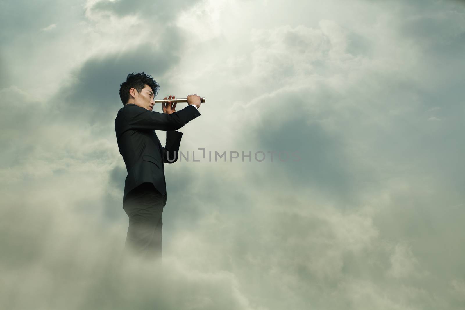 Young businessman looking through telescope in a dreamlike cloud by XiXinXing