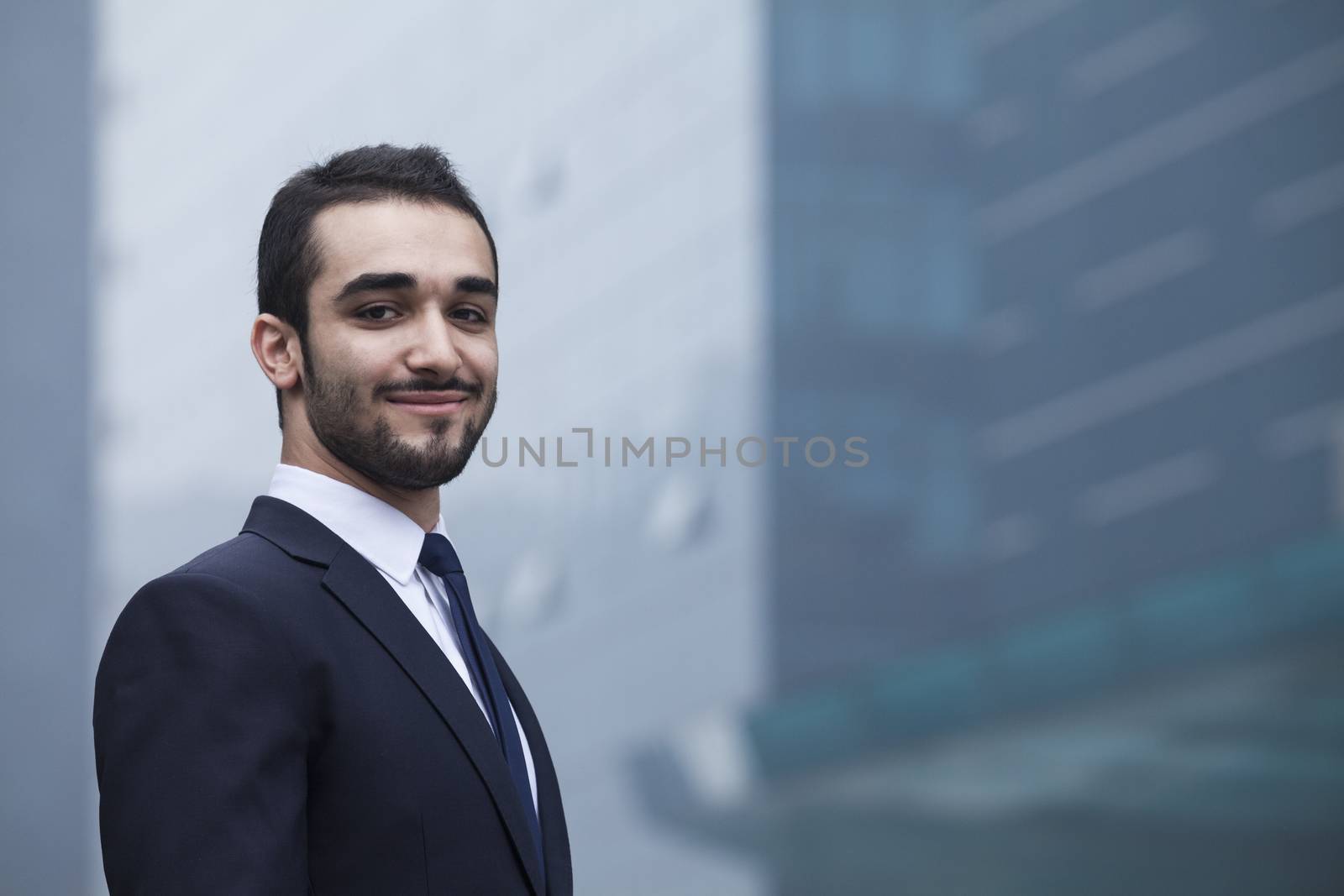 Portrait of smiling young businessman, outdoors, business district 