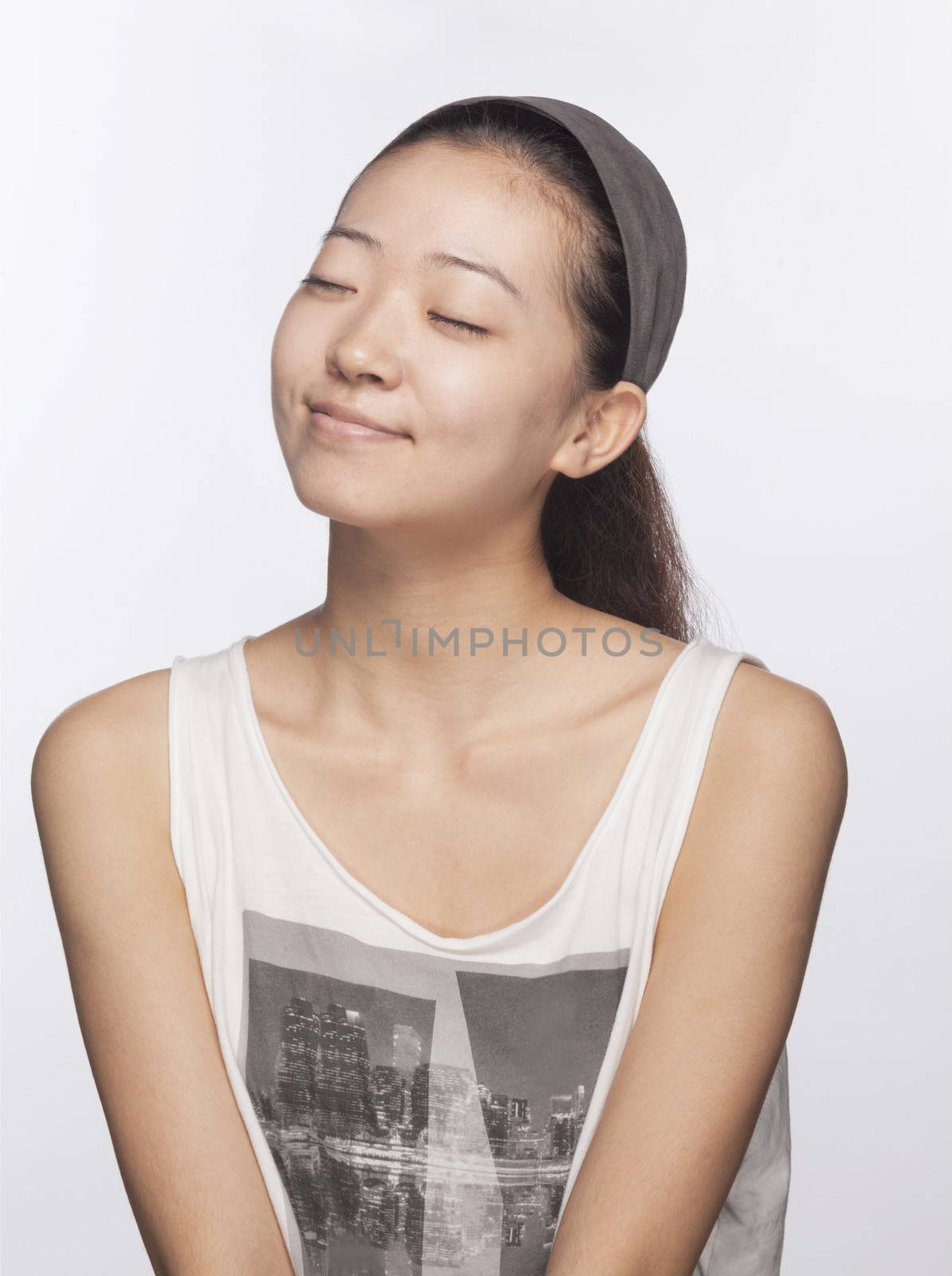 Smiling young woman with eyes closed, studio shot by XiXinXing
