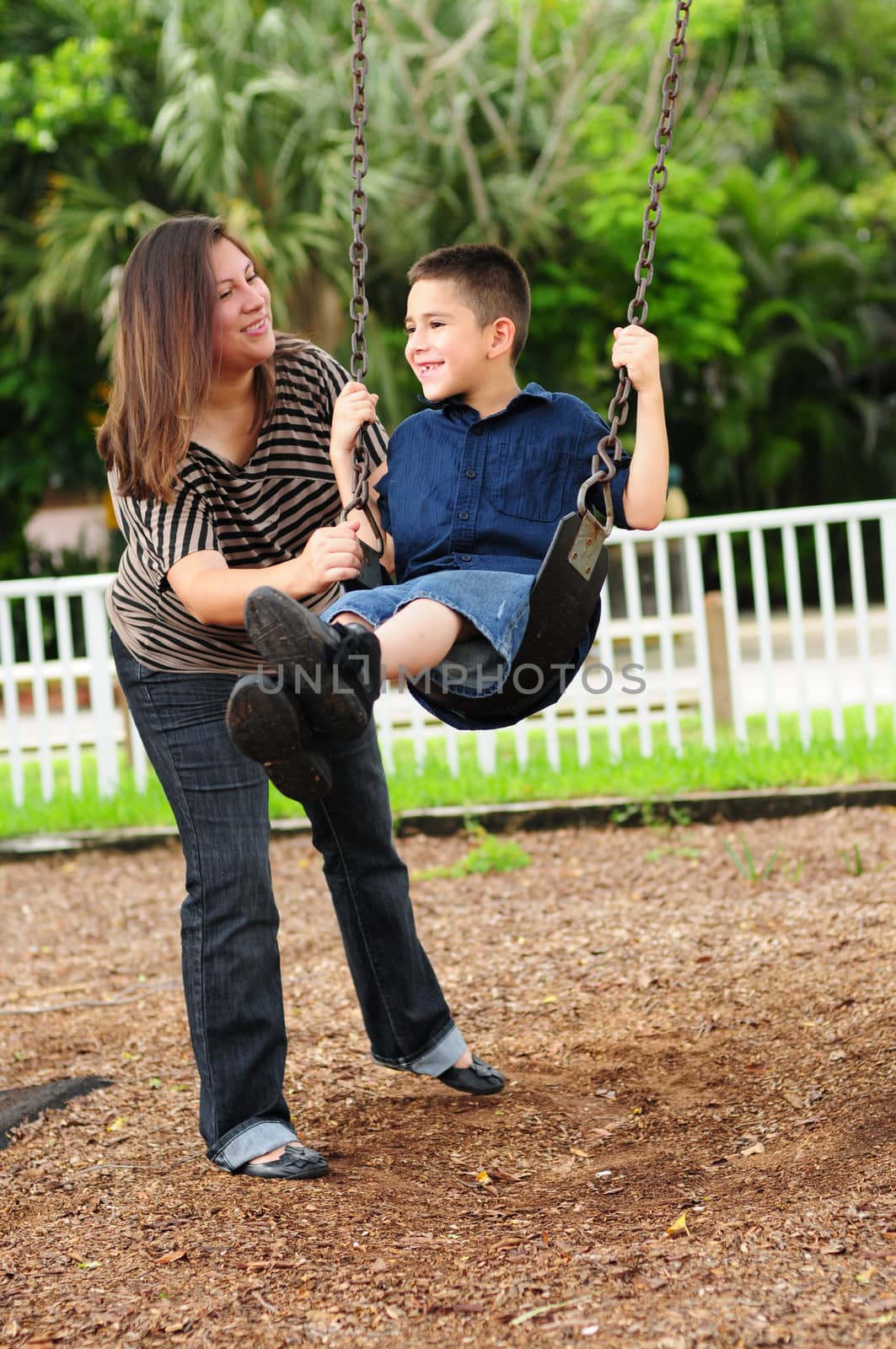 mother and child playing at park on swing