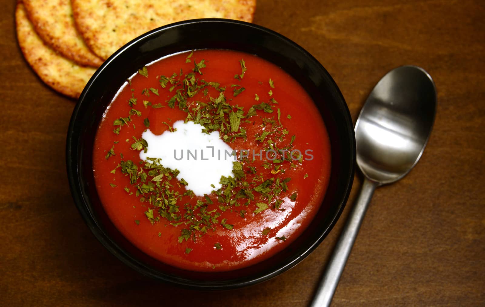 tomato soup and crackers on a rustic wooden background