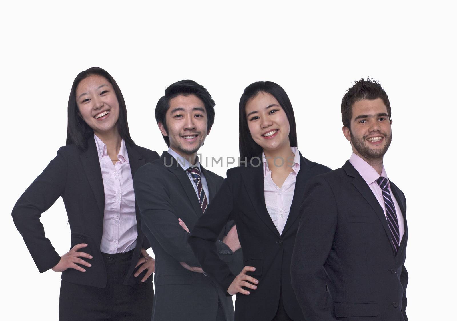 Portrait of four young business people looking at the camera, three quarter length, studio shot