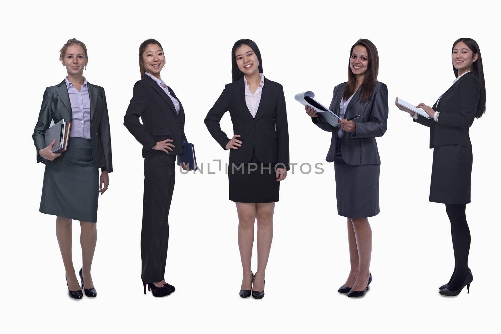 Portrait of five young smiling businesswomen, looking at camera, studio shot