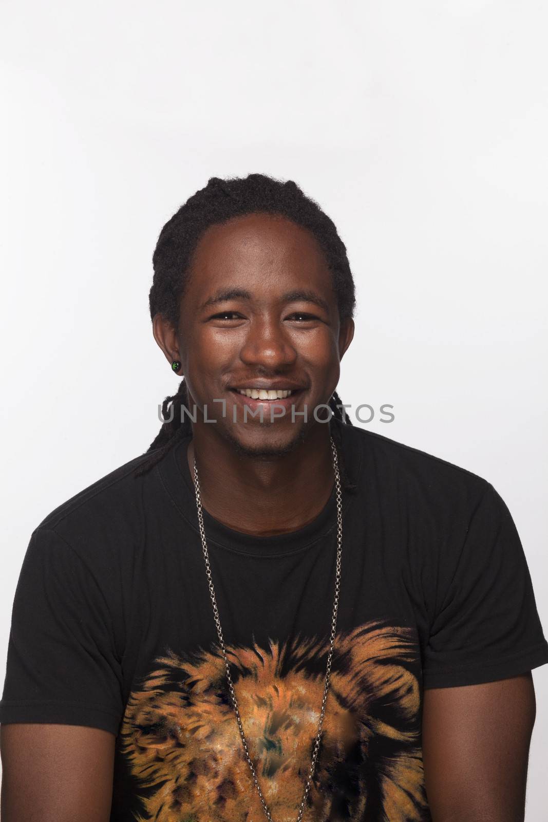 Portrait of young man with dreads smiling, studio shot