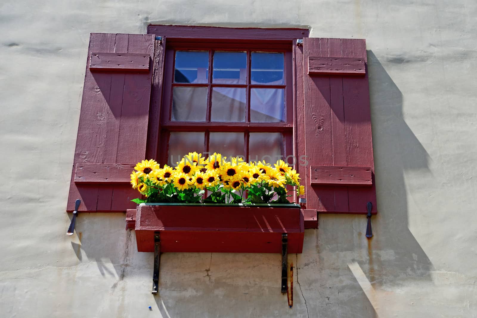 red shutters on window with flowers in renaissance city in europe