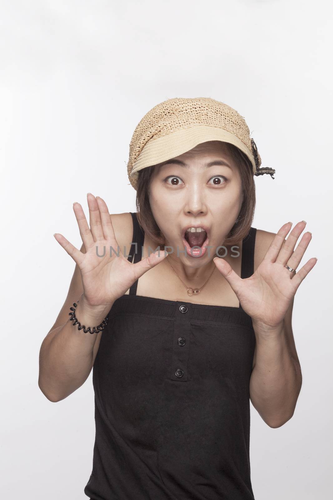 Portrait of surprised woman with hands raised, studio shot
