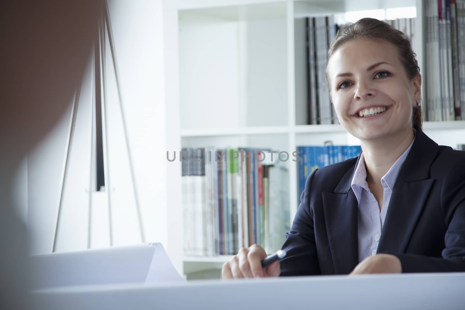 Young businesswoman smiling in the office during a business meeting by XiXinXing