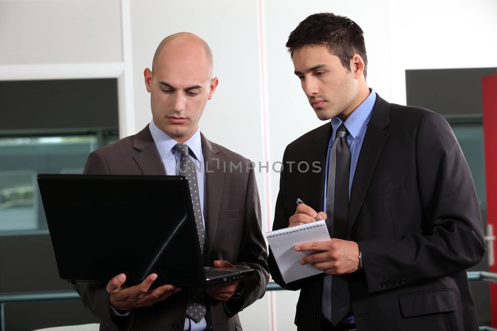 duo of young businessmen with laptop by phovoir