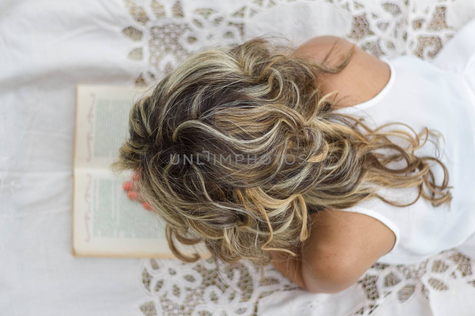 Beautiful young girl with book lying on the floor