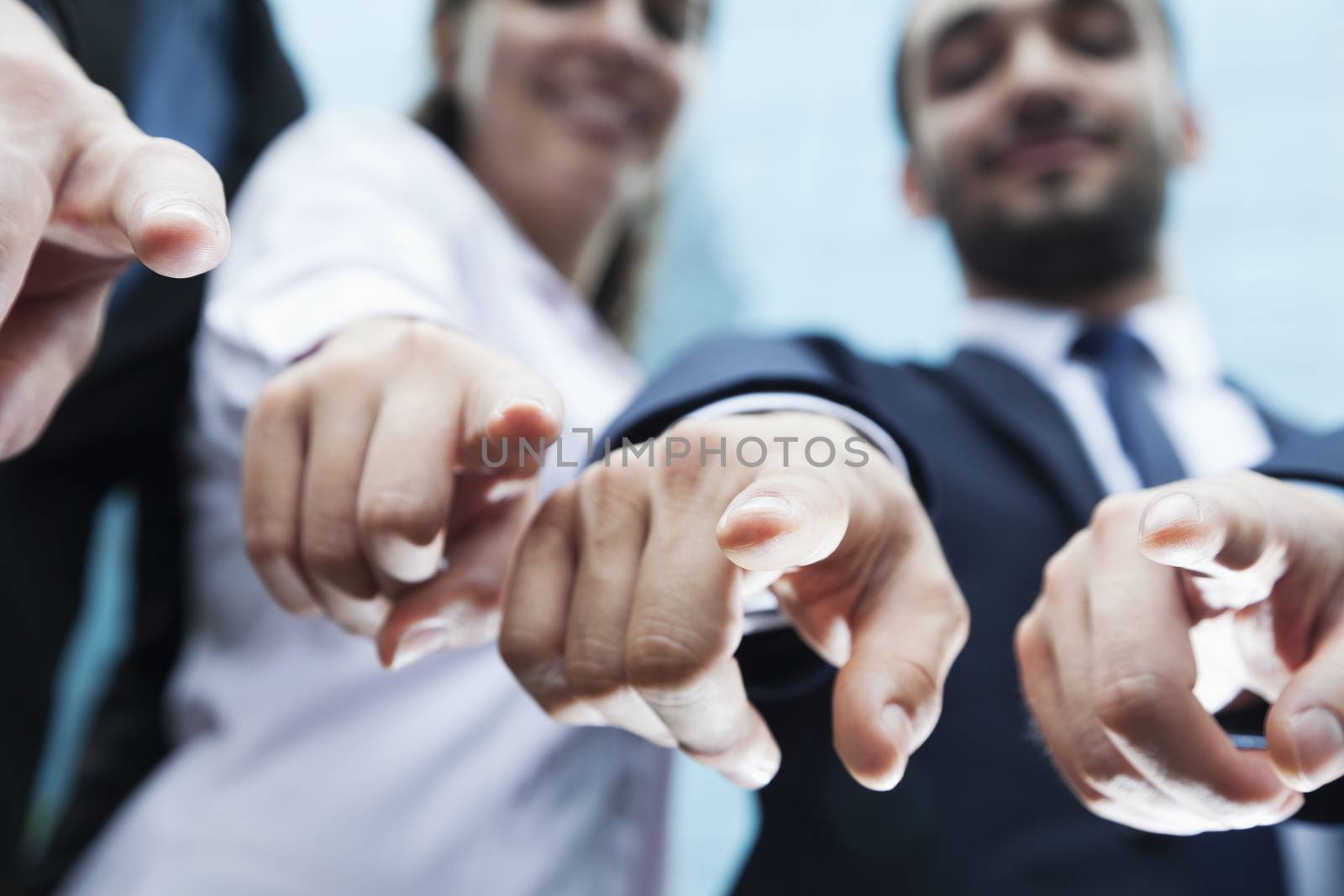 Close-up of four business people's fingers pointing at camera