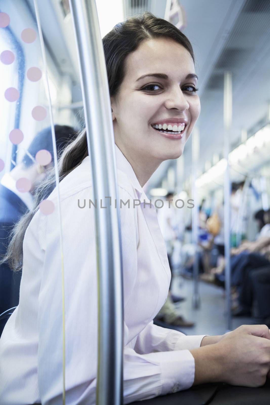 Portrait of young businesswoman sitting on the subway and looking at the camera