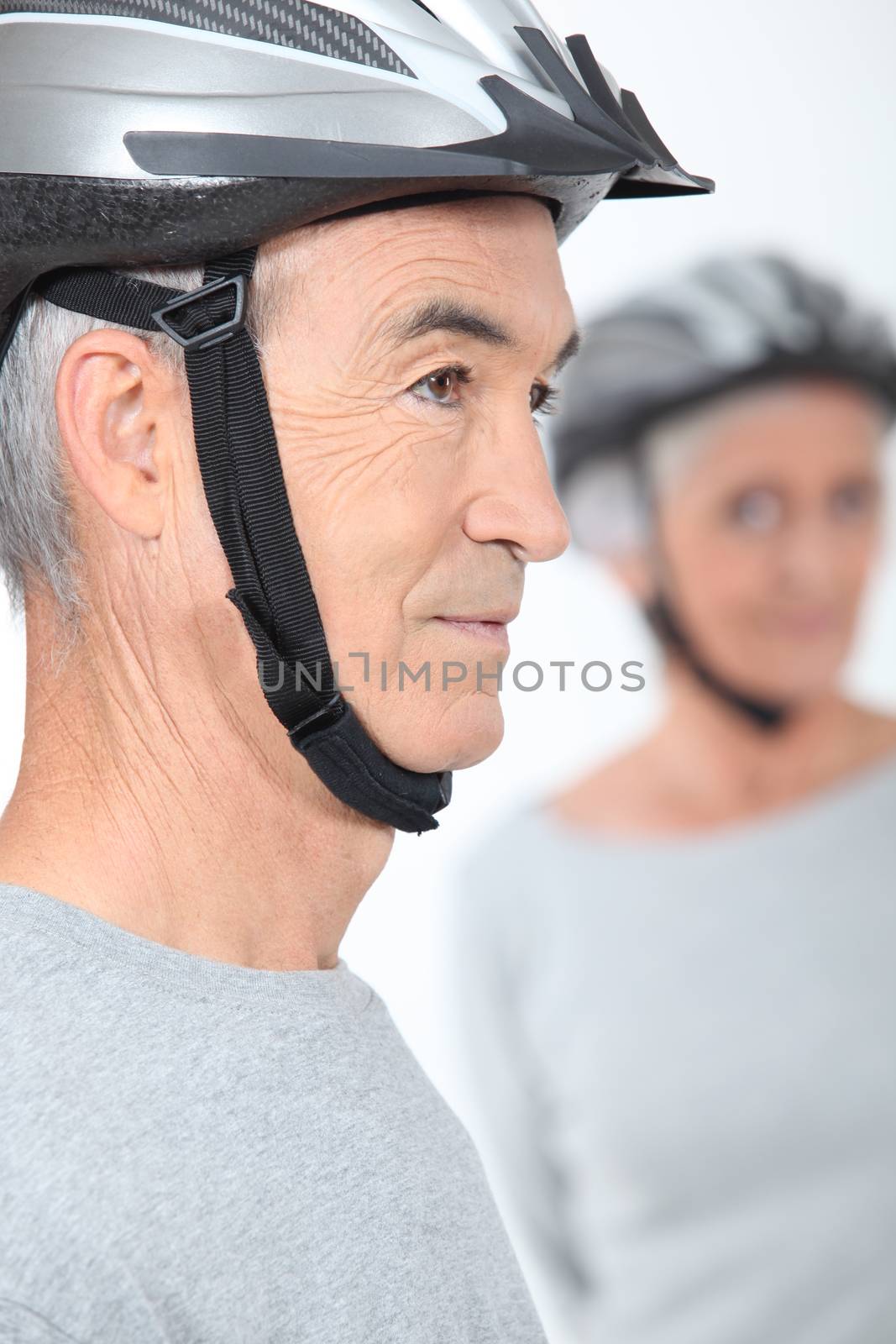Elderly couple with cycle helmets by phovoir