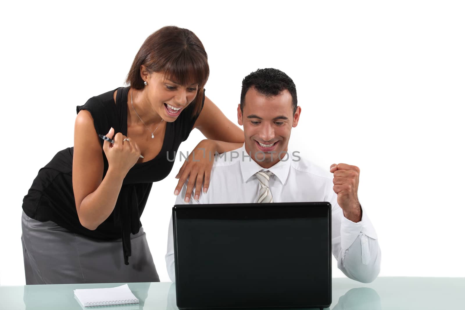 Excited business duo with laptop by phovoir