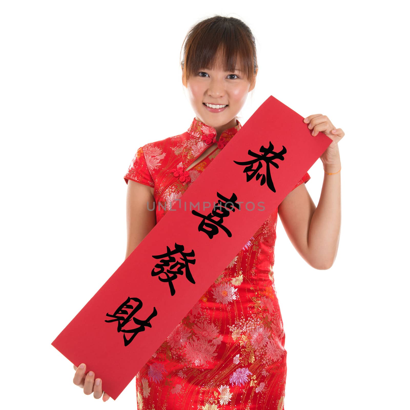 Asian woman with Chinese traditional dress cheongsam or qipao holding couplet, the Chinese word means congratulations and best wishes for a prosperous New Year. Female model isolated on white background.