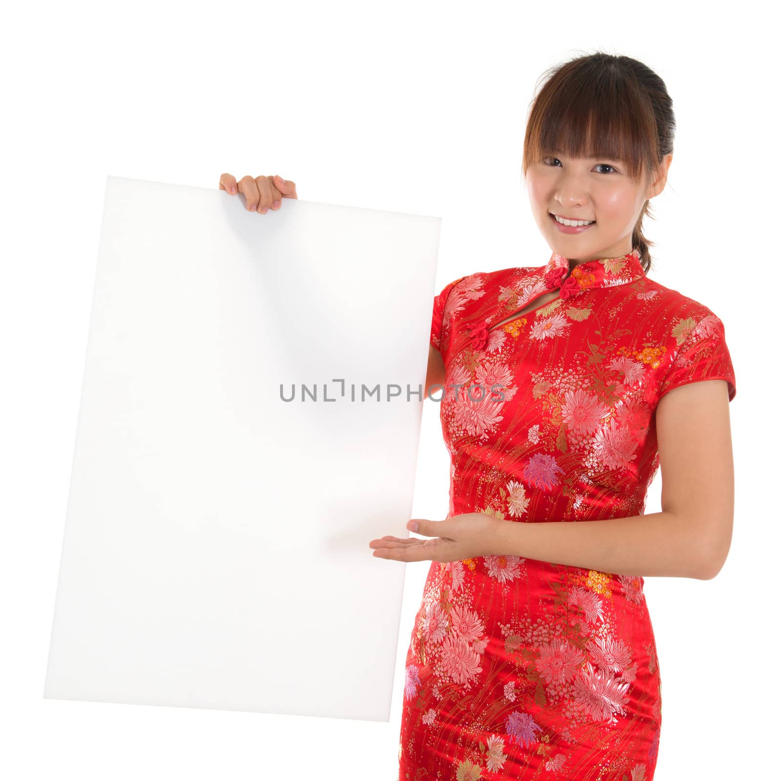 Asian woman with Chinese traditional dress cheongsam or qipao, holding blank white placard. Chinese new year concept, female model isolated on white background.
