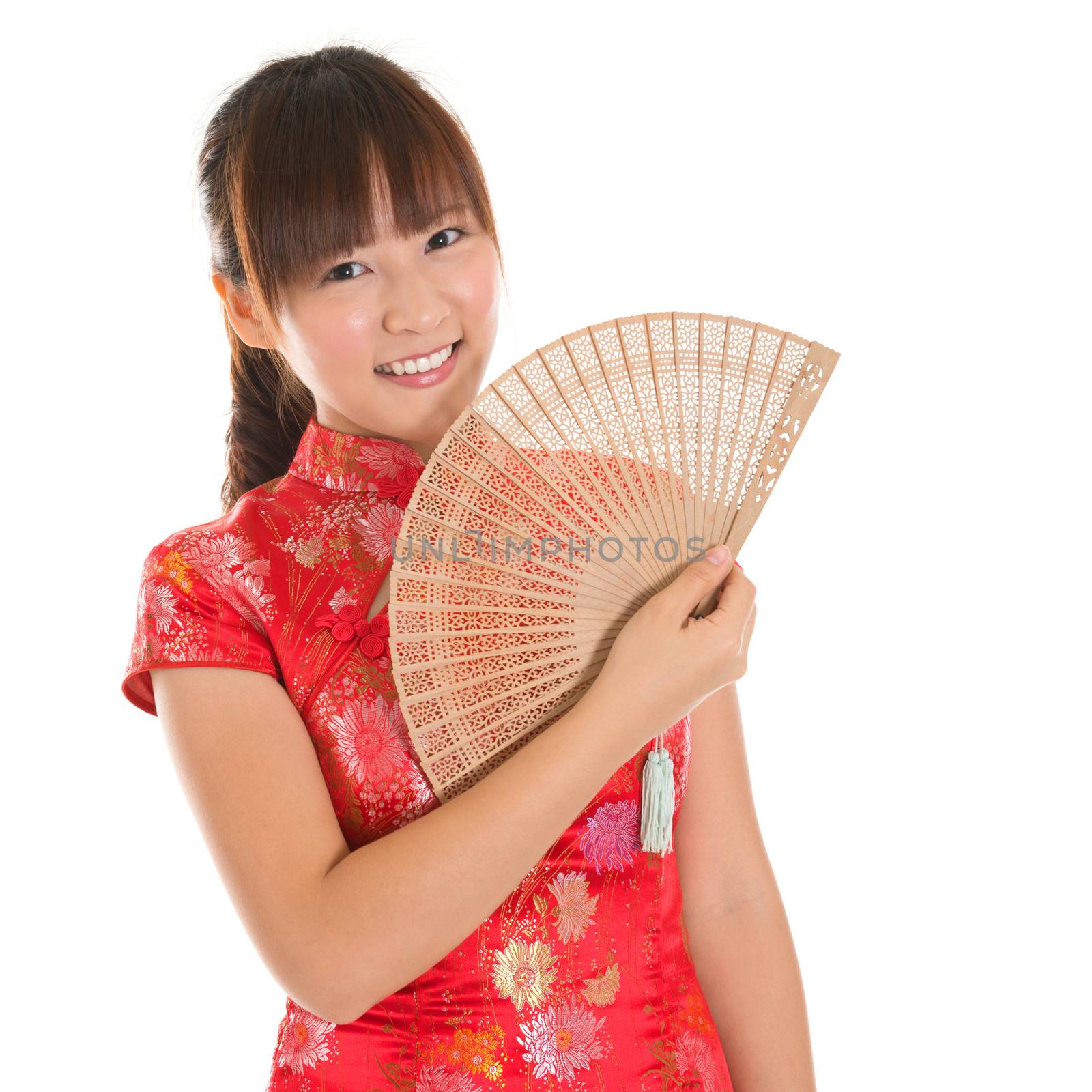 Asian woman with Chinese traditional dress cheongsam or qipao holding Chinese fan. Chinese new year concept, female model isolated on white background.