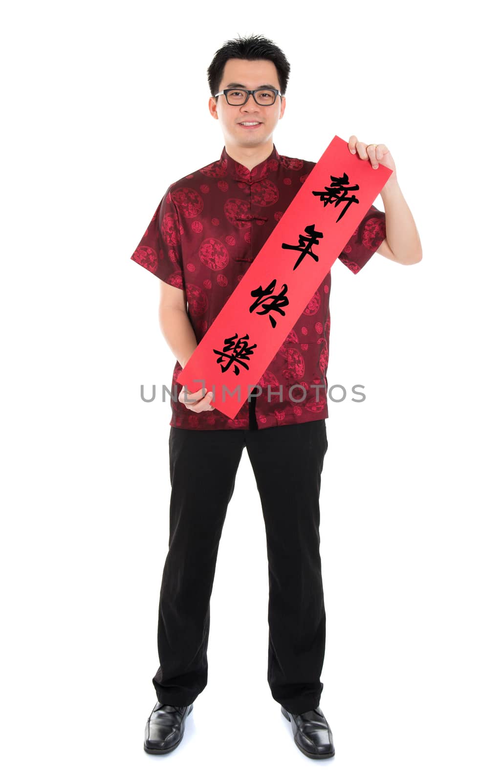 Full length Asian man with Chinese traditional cheongsam or tang suit holding couplet, the Chinese word means Happy New Year.  Male model isolated on white background.