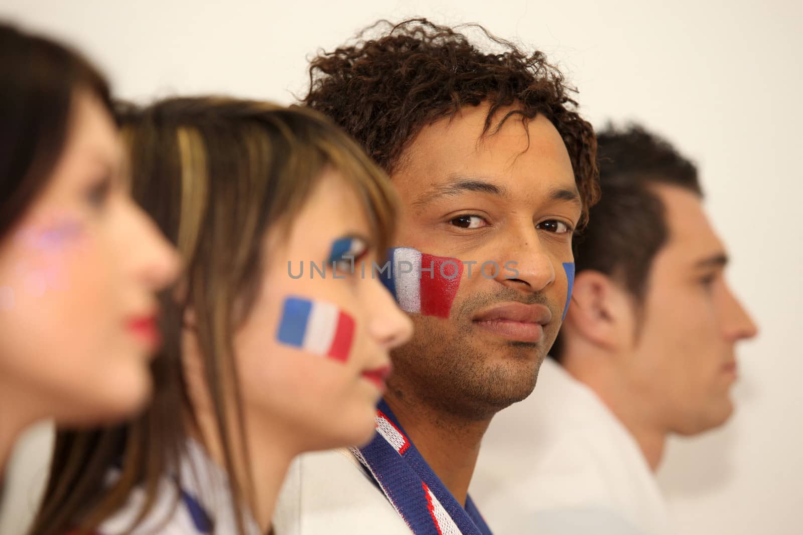 Four French sports fans stood in anticipation by phovoir