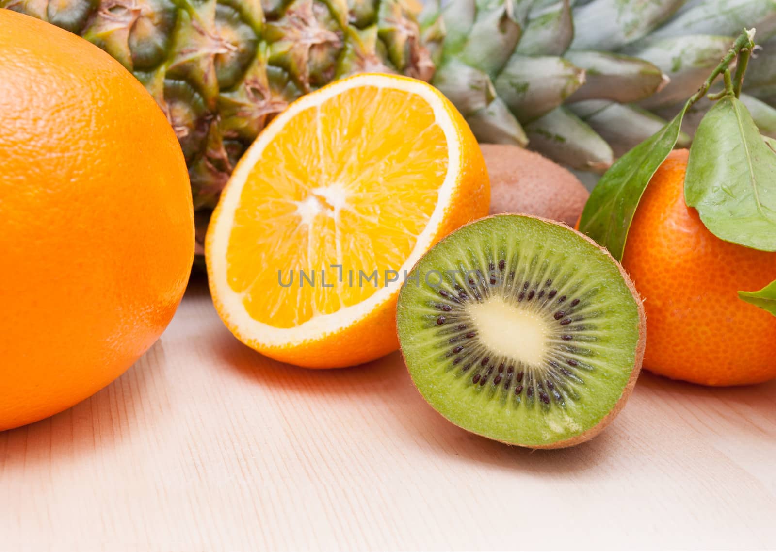 Tropical Fruits - Pineapple, Oranges, Tangerine and Kiwi on Wooden Table With Copyspace