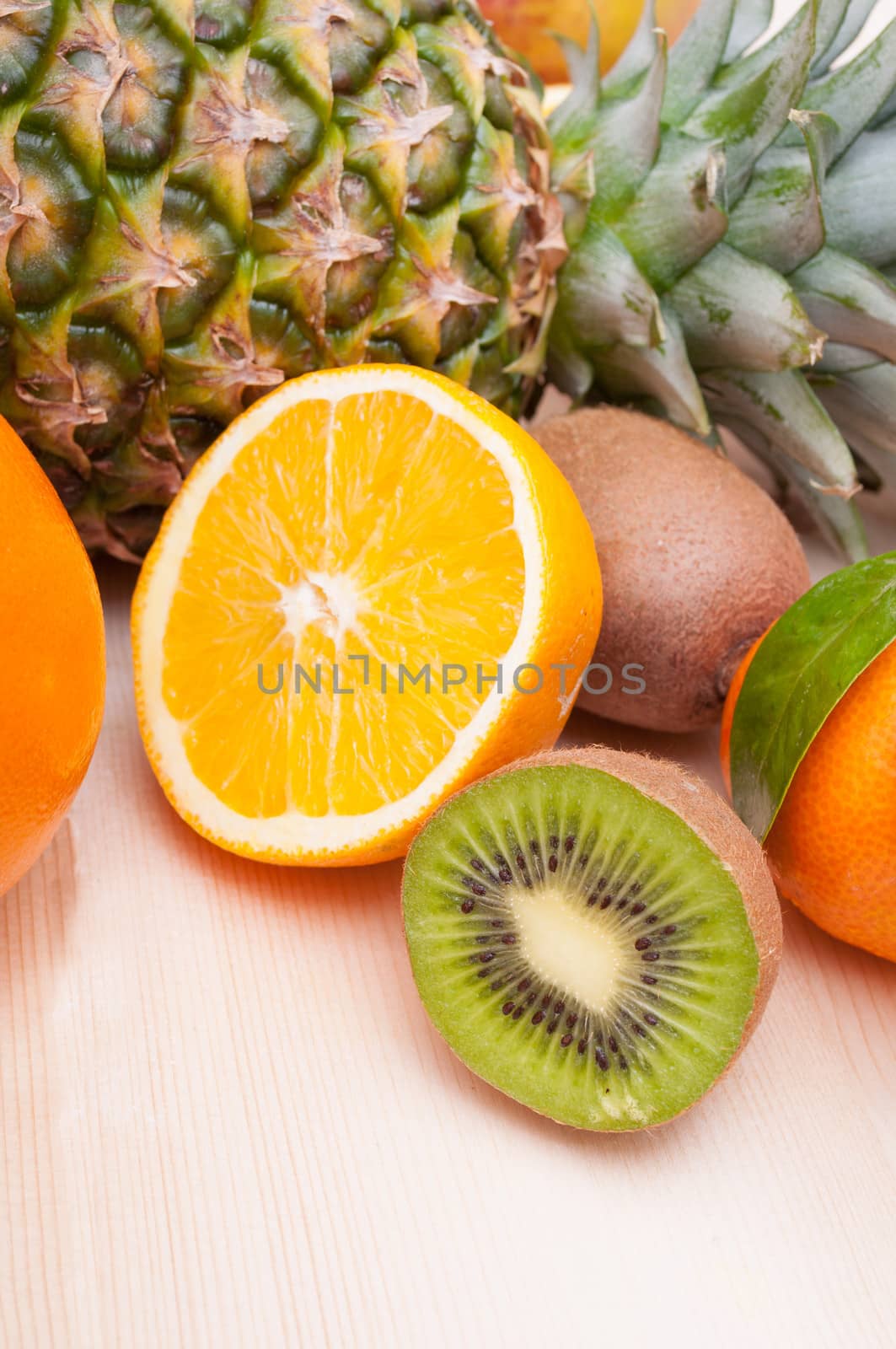 Tropical Fruits - Pineapple, Oranges, Tangerine and Kiwi on Wooden Table With Copyspace