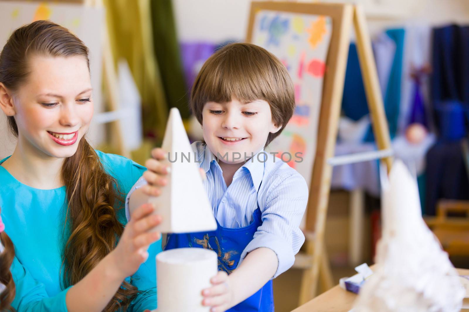 Young teacher and children painting and playing