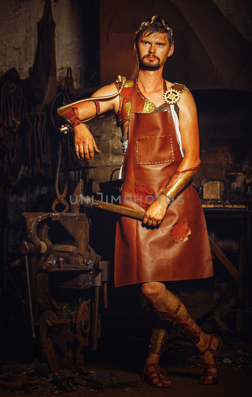 Hephaestus blacksmith in a leather apron in the blacksmith with hammer and clippers, anvil