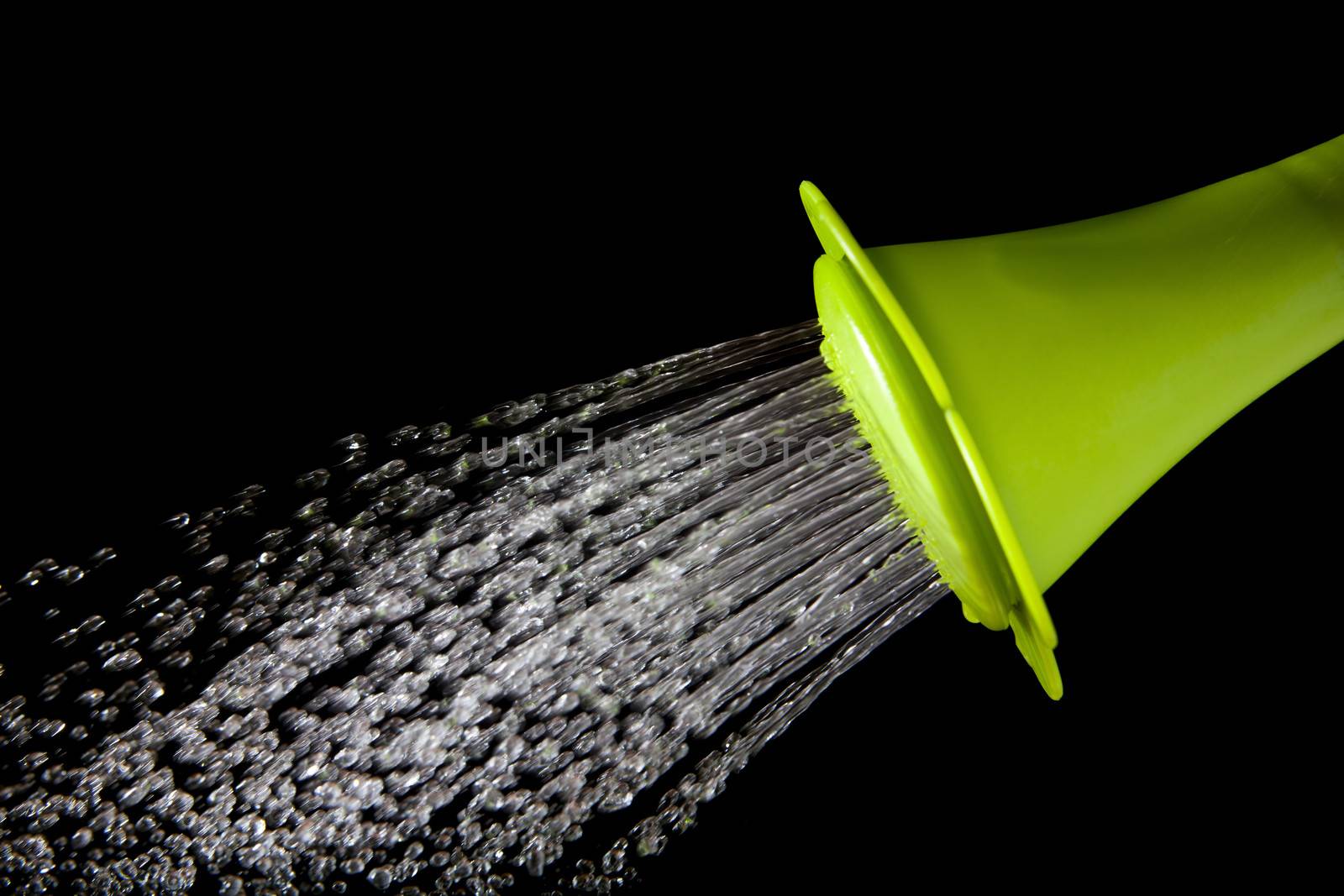 green watering can pouring water with high speed shutter isolate by khunaspix