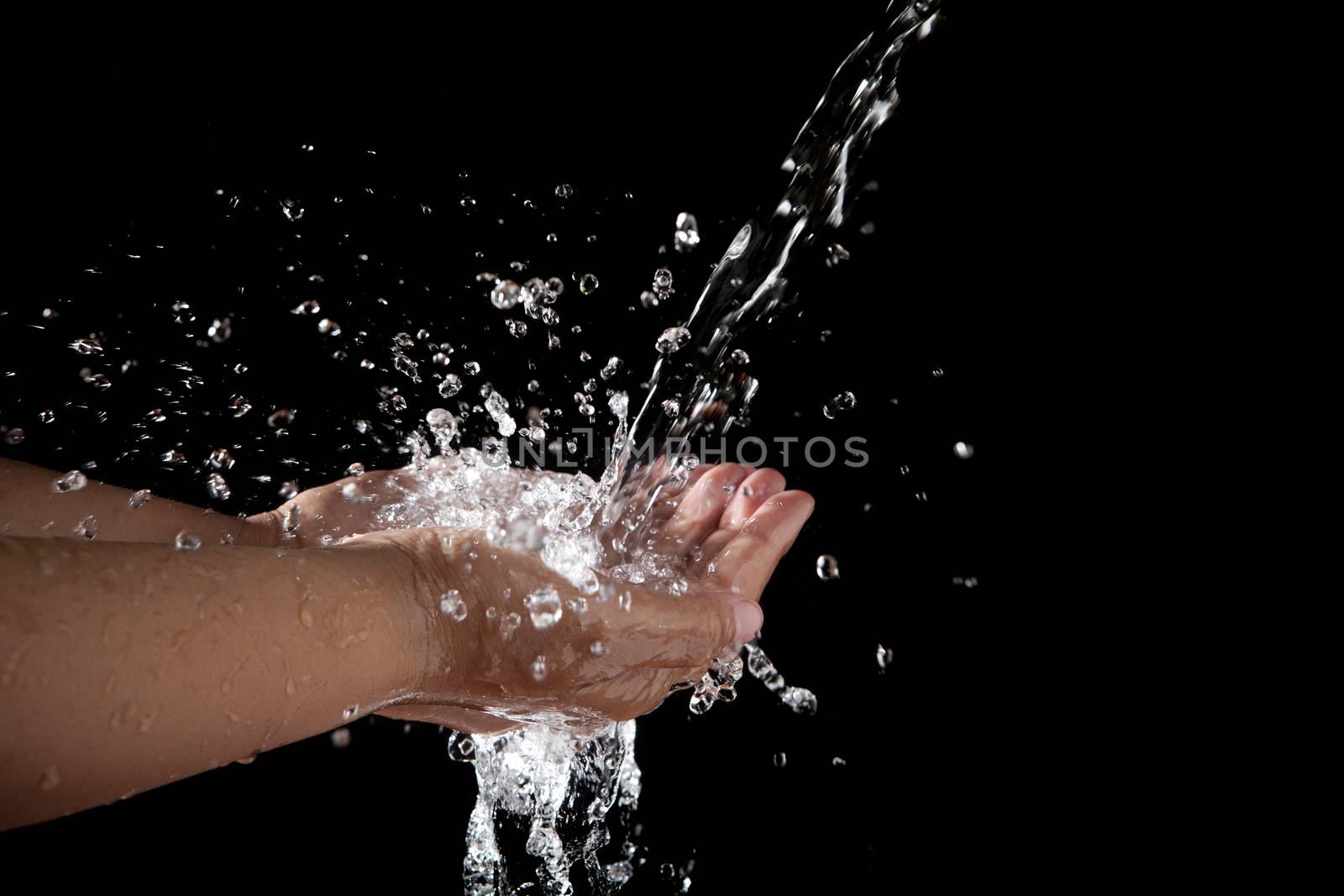 hand and pouring water on black background by khunaspix