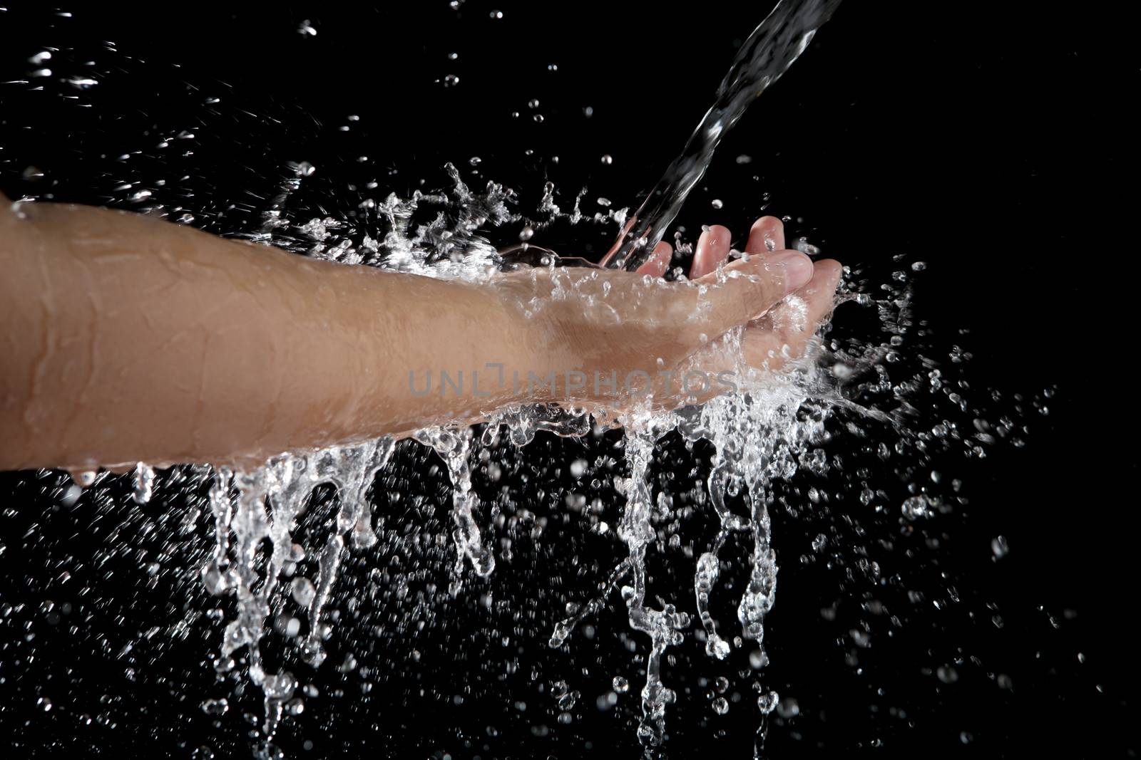 hand and pouring water splashing  on black background 