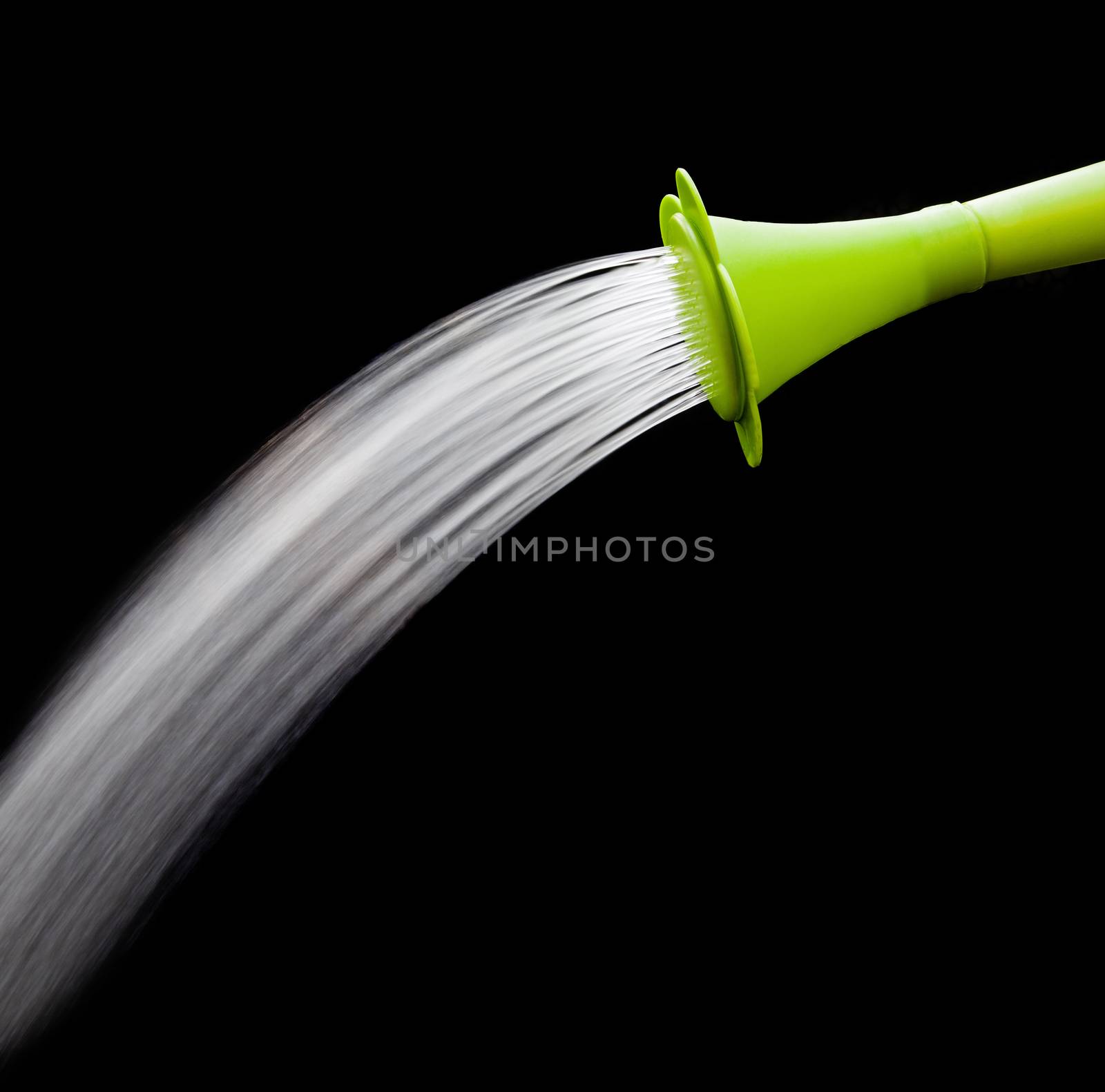 green watering can pouring water with slow speed shutter isolated on black