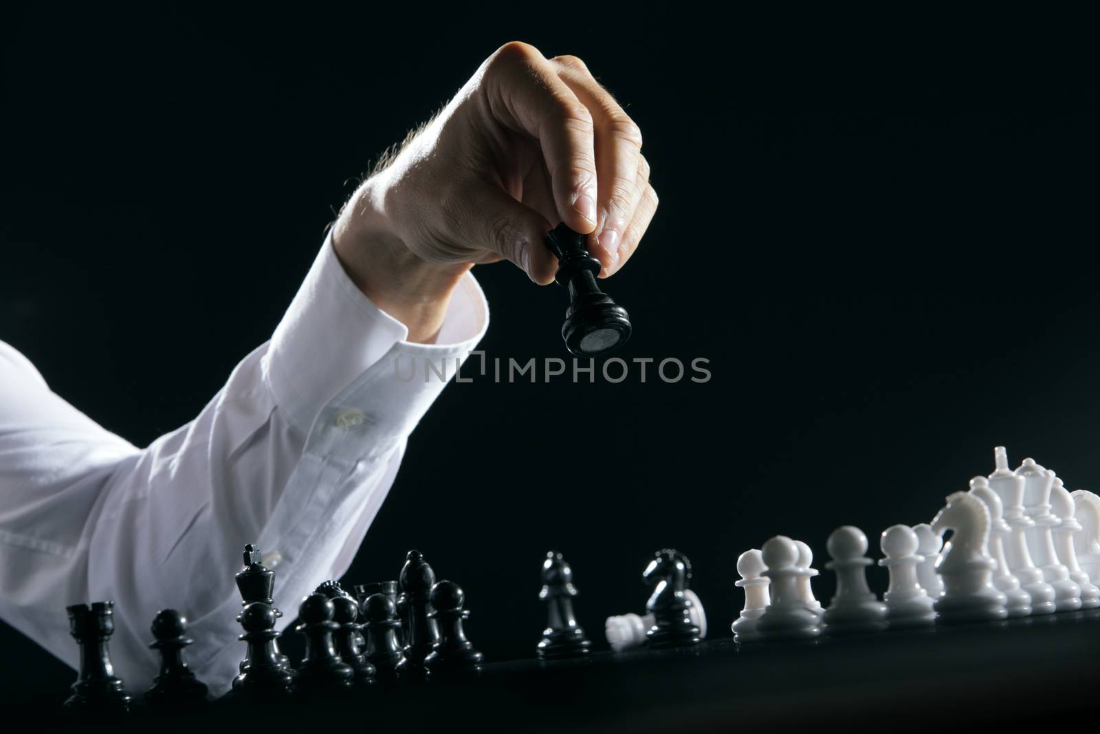 Male hand moving the queen in a chess game.